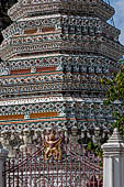 Bangkok Wat Arun - Entrance to the base with one of the four corner prangs, note the Royal seal at the fence.